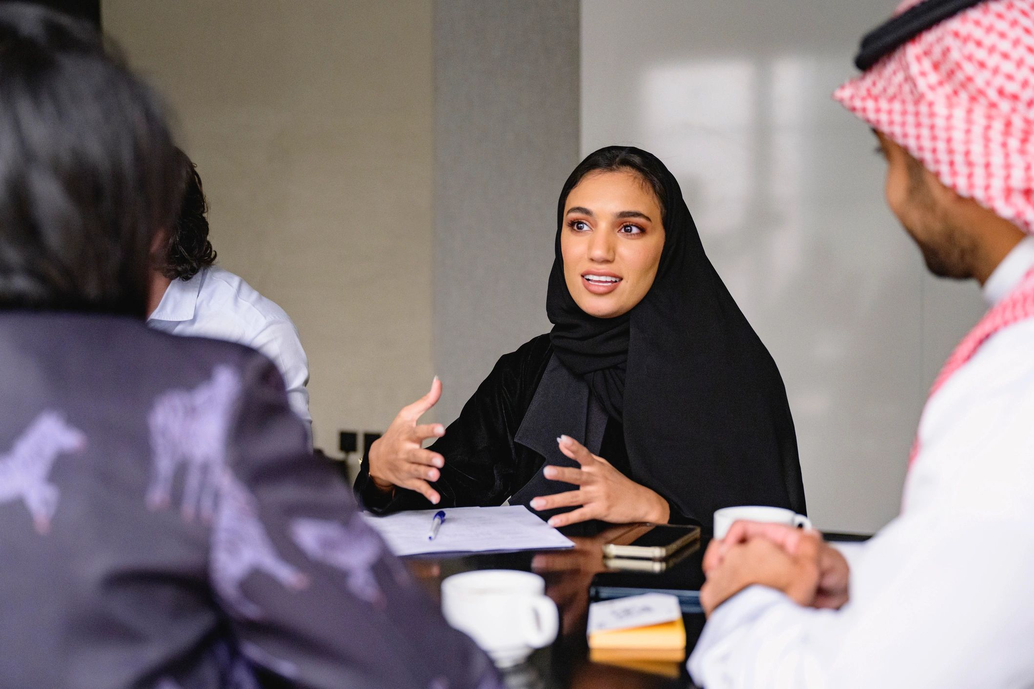 Saudi business professional collaborating at a meeting table