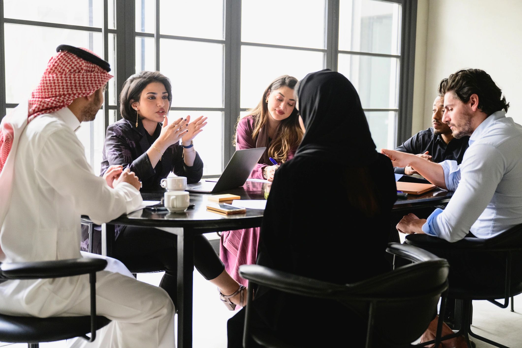 Saudi business team discussing solutions in a meeting room