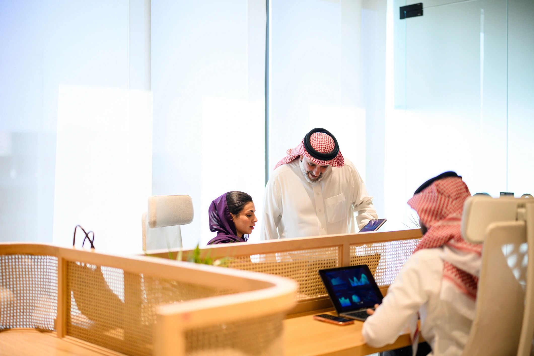Saudi business professionals discussing HR operations in an office